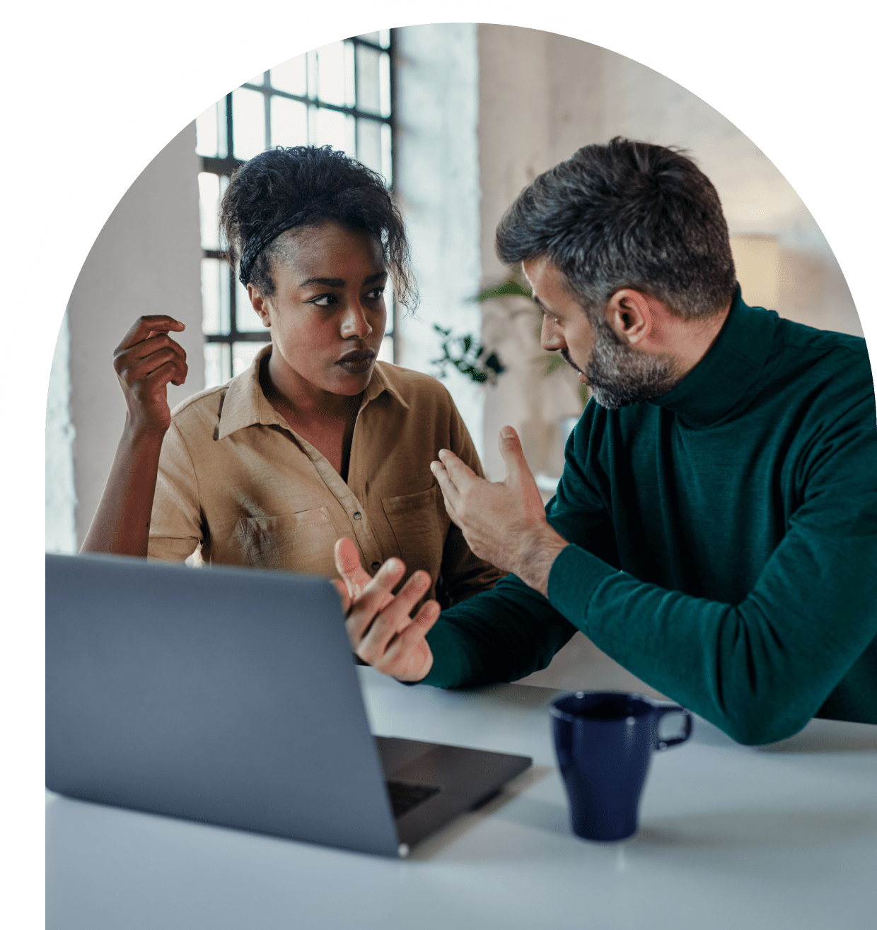 Two colleagues discussing at a table.