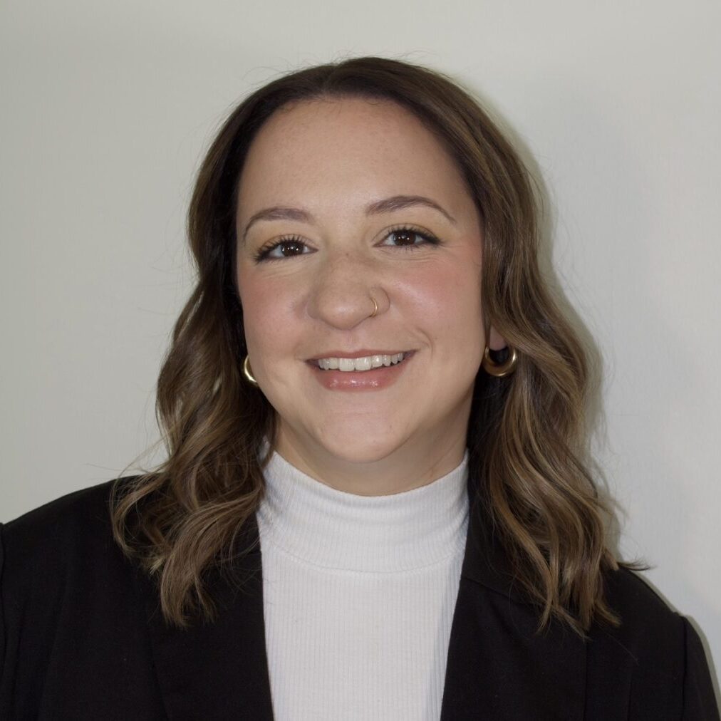 Smiling woman with shoulder-length brown hair and a black blazer.